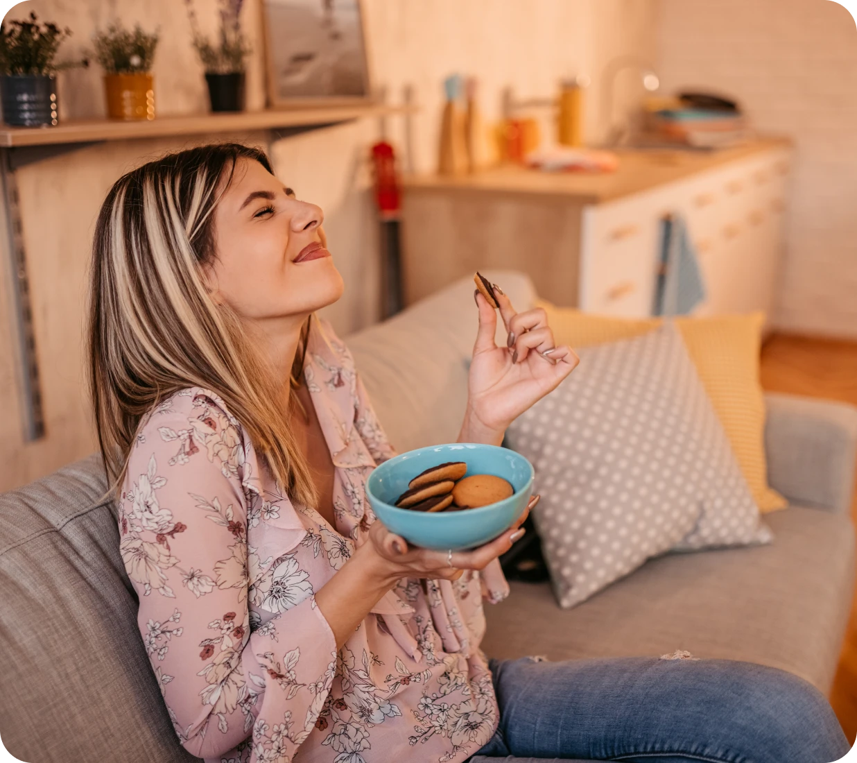 Woman enjoying cookies on a sofa